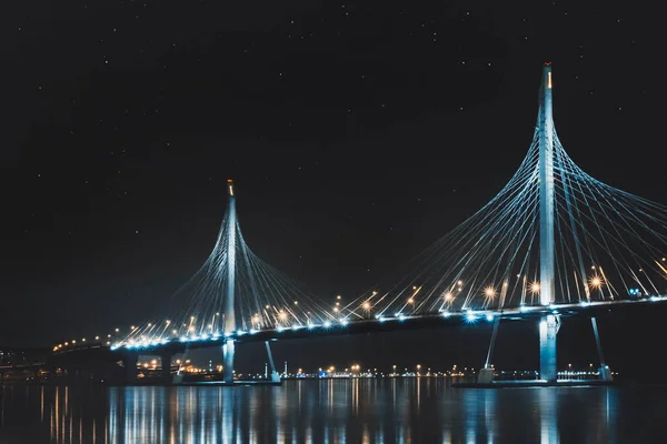 Beautiful cable-stayed bridge in St. Petersburg, Russia, with starry sky and cozy city lights — Stock Photo, Image