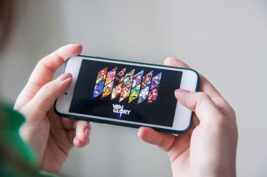 Los Angeles, Kaliforniya, ABD - 25 Şubat 2019: Eller Vainglory MOBA oyununun olduğu akıllı telefonu ekranda tutuyor,