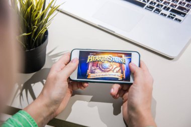 Los Angeles, Kaliforniya, ABD - 25 Şubat 2019: Hearthstone giriş ekranında akıllı telefonu tutan eller