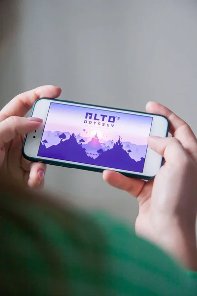 Los Angeles, California, USA - 25 February 2019: Hands holding a smartphone with Altos Odyssey game on display screen — Stock Photo, Image