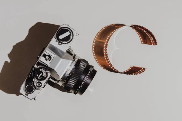 Geometrikus lapos fektetett készlet: vintage kamera világos hátterű 35 mm-es filmszalag. Felülnézet. — Stock Fotó