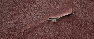 Yıpranmış ve duvardaki boyaları soyulmuş. Duvarda koyu kahverengi boya var. Eski beton duvarda çatlaklar ve kabuklar var, beton duvarın yüzeyinde çizikler ve soyulmuş boyalar var..