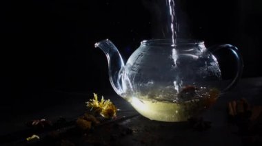 bir mavi arka plan, natrmort çay ve çiçeklerle, bir fincan içine dökülür çay çaydanlık