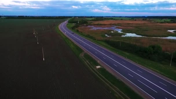 Шоссе, движение автомобилей по шоссе. Асфальтовая дорога в России, вид на озеро Лотос. Стрельба с помощью квадрокоптера . — стоковое видео