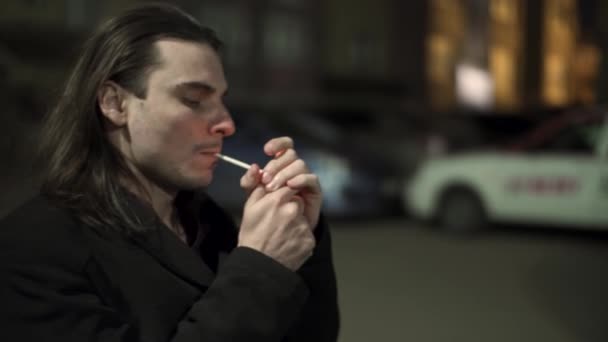 A sad Young man sets fire to a cigarette. Depression. Nervously Smoking a cigarette at night. — Stock Video