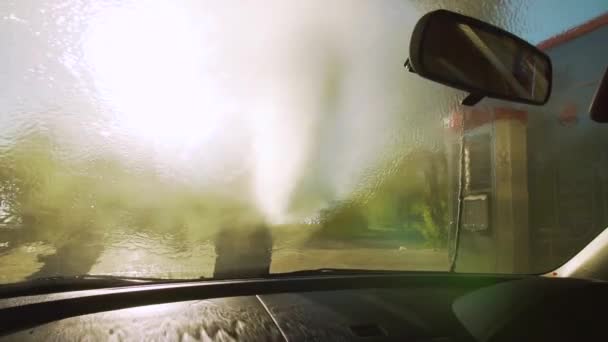 Rusia, Krasnodar, abril 2018, auto-servicio de lavado. Un joven lava el parabrisas. Vista a través del parabrisas . — Vídeos de Stock