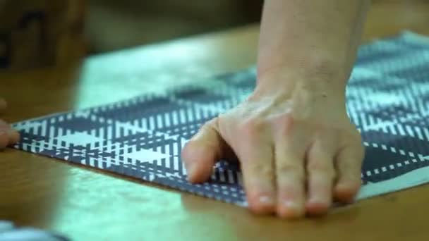 PartMaker cuts the fabric. The girl cuts the fabric with scissors. Scissors cut a strip of fabric. — Stock Video