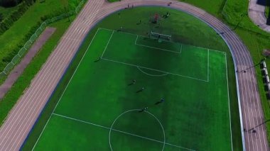 Güzel yeşil futbol stadyumu. Gençler futbol oynuyorum. Futbol sahası bir kuş uçuş.