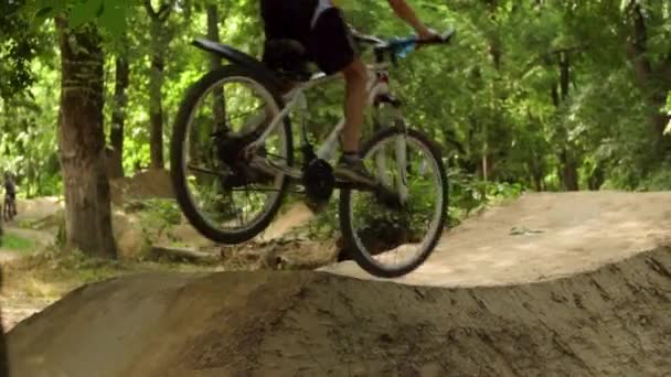 El chico de la moto. Ciclista en el bosque. Cabalgando y saltando sobre obstáculos. Ruedas de Bicicleta salen del suelo . — Vídeos de Stock