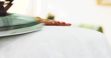 Kadın el Beyaz kumaş bir demir ile iş yerinde okşayarak. Beyaz kumaş üzerine demir yakın çekim