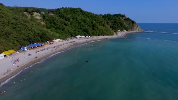 People swim in the sea. Blue Bay of the Black sea Beautiful beach in the black sea region of Krasnodar region. Beach tents. Aerial view. — Stock Video