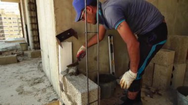 Bir beton duvar bir spatula ile alt yapılar üzerinde beton blok çözüm koyar. Anapa, Krasnodar bölgesi 28 Haziran 2018