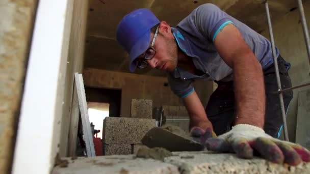Pracownik buduje betonowa ściana z łopatką umieszcza rozwiązania betonowego bloku. Anapa, Krasnodar region 28 czerwca 2018 r. — Wideo stockowe
