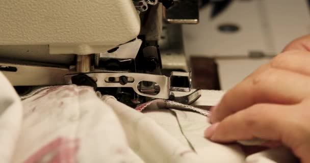 Máquina de coser profesional overlock con tela blanca de cerca — Vídeos de Stock