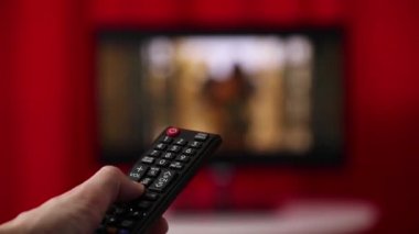 Elini tut Tv uzaktan kumanda. TV arka planda.