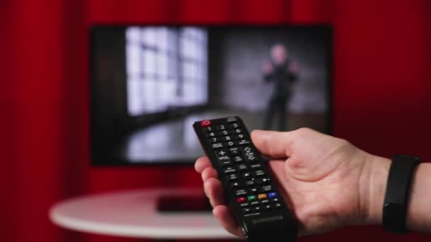 Télécommande de la télévision à main. TV en arrière-plan .