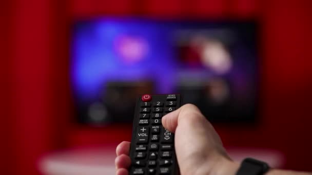 Telecomando TV a mano. TV sullo sfondo . — Video Stock