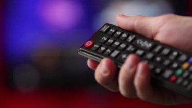 Elini tut Tv uzaktan kumanda. TV arka planda.