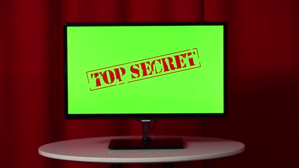 Flat screen TV. Standing on a white table. Green screen. Top secret. Red background. — Stock Video