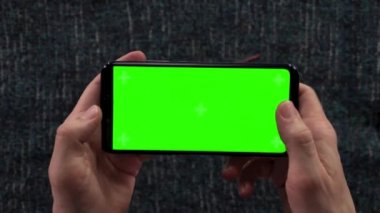 Mens yakın çekim yatay yeşil ekran arka plan gardırop giyim hazırlanması ile akıllı telefon holding eller. Tasarımcı çizim. Moda Tasarımcısı çizimler eğitim.