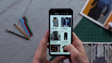Mens Close-Up holding akıllı telefon içinde belgili tanımlık geçmiş'deki dikey yeşil ekran eller. Giyim satın alma. Çevrimiçi mağaza arama. Online alışveriş.