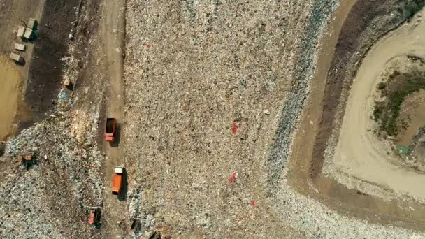 Gran camión de basura naranja se mueve a través de un enorme vertedero un enorme vertedero de basura — Vídeos de Stock