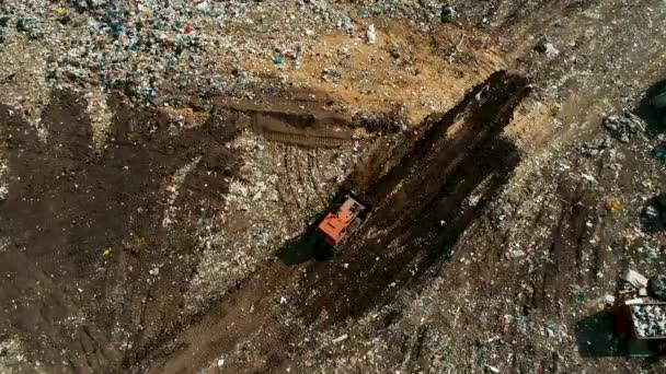 Bulldozer i en öppen deponi av fast avfall, rävar en massa sopor. — Stockvideo