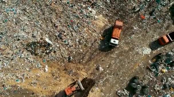 Grande camion della spazzatura arancione il cestino in una discarica enorme . — Video Stock