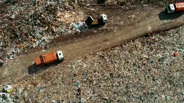 Grande camion della spazzatura arancione in movimento tra i detriti. discarica. Attrezzature di lavoro presso il sito . — Video Stock