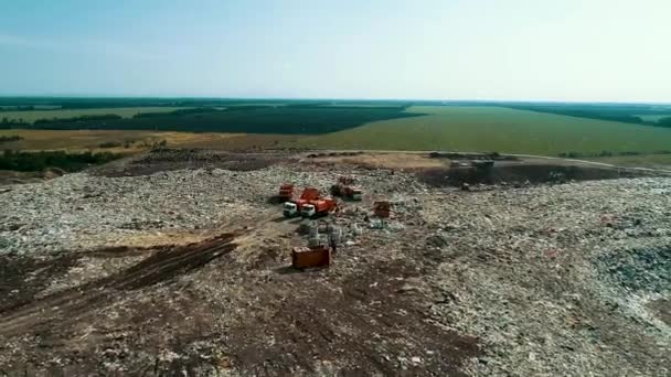 Grandes ordures de camion à ordures orange dans énorme décharge. Équipement de travail sur le site . — Video