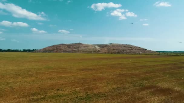 Une énorme pyramide d'ordures. Vue panoramique de la montagne des ordures parmi les champs . — Video