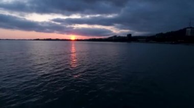 Ufukta deniz kıyısında gün batımı şehir manzarası gün batımı. Sukhumi, Abhazya.