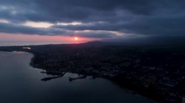 Ufukta deniz kıyısında gün batımı şehir manzarası gün batımı. Sukhumi, Abhazya.