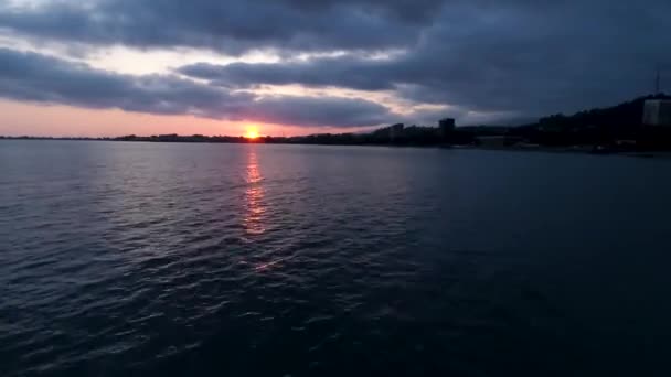 Zonsondergang op de kust stadsgezicht zonsondergang aan de horizon. Sukhumi, Abchazië. — Stockvideo