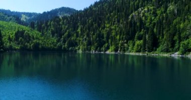 Abhazya'daki Malaya Ritsa Gölü mavi dağ. Yüksek dağların manzarası ile su üzerinde panoramik görünümü.