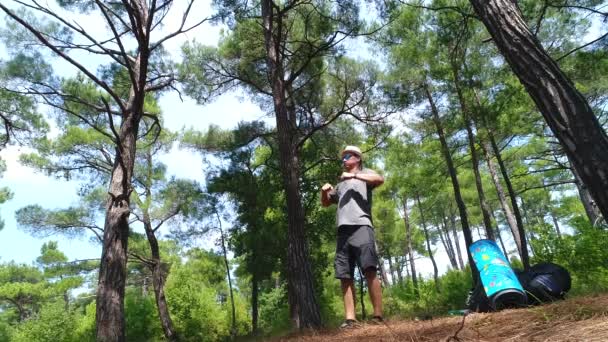 Un jeune homme par derrière un touriste sur un sentier forestier va avec un sac à dos dans une tente de forêt de pins dans ses mains région de Dzhankhot Krasnodar Août 2019 — Video