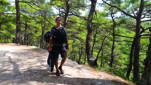 Tânărul turist se mută pe rucsacul forestier. Dzhankhot Regiunea Krasnodar August 2019 — Videoclip de stoc