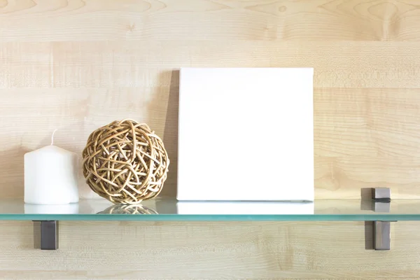 White canvas on a stretcher in a neutral interior. Mockup poster. Glass shelf and wooden board on background.