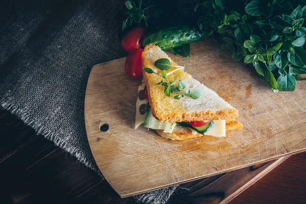 Toast with maasdam cheese, tomato, cucumber and basil. Tasty breakfast or lunch.