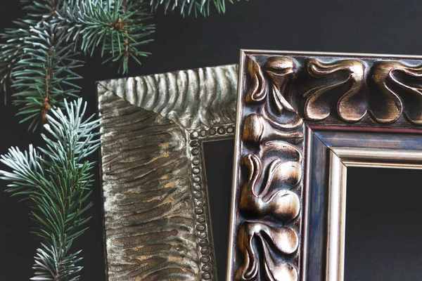 Decorative frames and pine branch on black background. Framing workshop concept.
