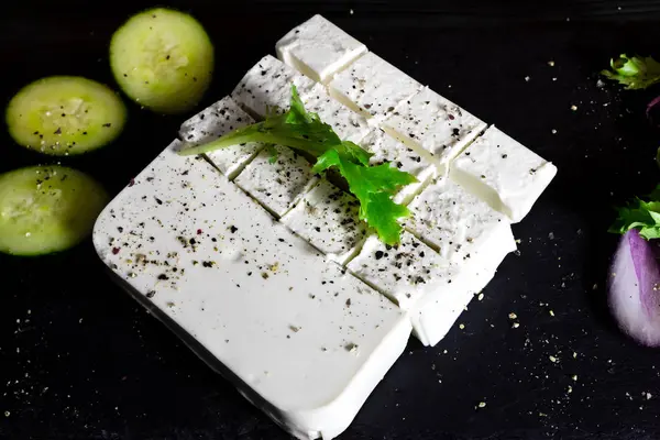 Feta cheese with spices. Fresh greek cheese, cucumber and onion.