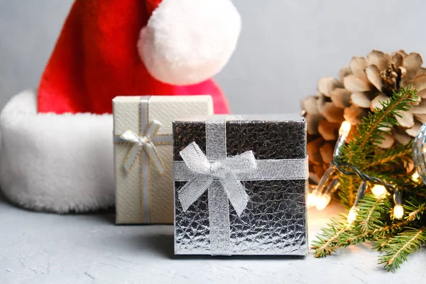 Christmas gift boxes, Santa hat and Christmas tree twig with lights. Christmas presents concept.