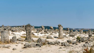 Ancient Stone Formations in Arid Landscape Under Clear Blue Sky