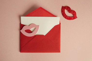 Mockup kırmızı zarf ve beyaz sayfa boş boş pembe renkli masa üzerinde. İş boş mock-up arka plan mesaj yazmak için. Üstten görünüm. Yatay