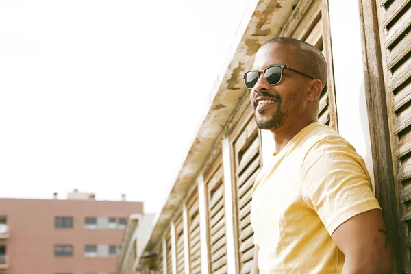 Портрет счастливого привлекательного молодого афро-американского хипстера в футболке, идущего по солнечной улице. . — стоковое фото