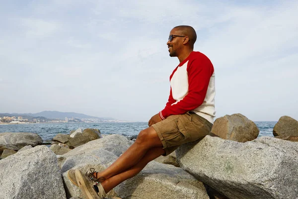 Sonriente joven hipster afroamericano disfrutando de un día de verano en la playa fuera de la ciudad . —  Fotos de Stock