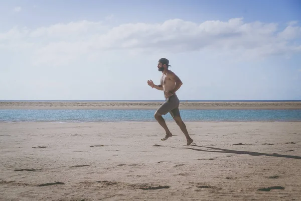 Corredor joven corriendo por la mañana a lo largo de la playa . —  Fotos de Stock