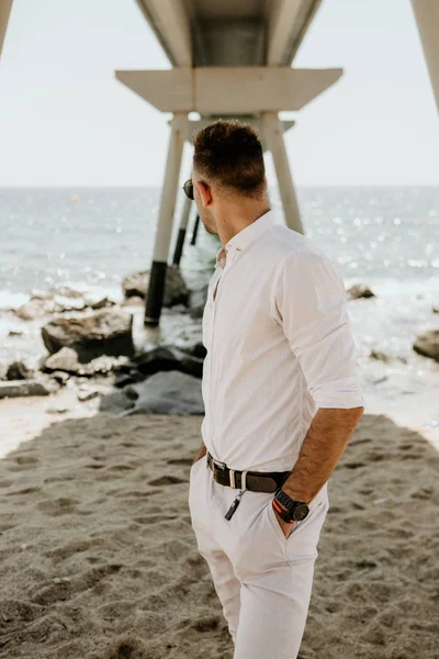 Travel concept voor de vakantie van de vakantie. Knappe gelukkig man dragen witte shirt en zonnebrillen op de zee of de oceaan achtergrond. Verticaal. — Stockfoto