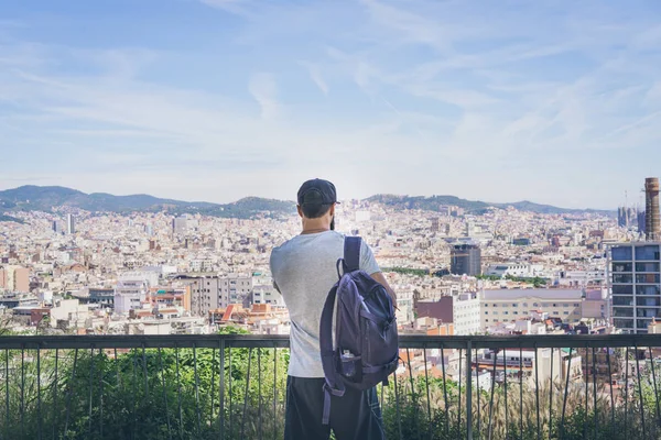 Bearded Tourist Man with backpack enjoy beautiful panoramic view of modern european city.Traveler man looking on a big city, travel and active lifestyle concept.