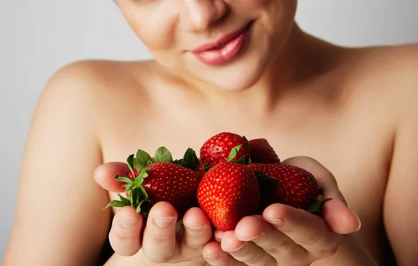 Pretty happy smiling woman with many strawberry over colorful white background. — Stock Photo, Image